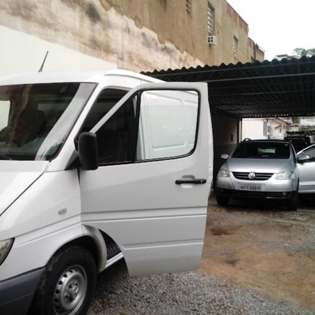 Van de atendimento da Quaglicar e carros no pátio da loja