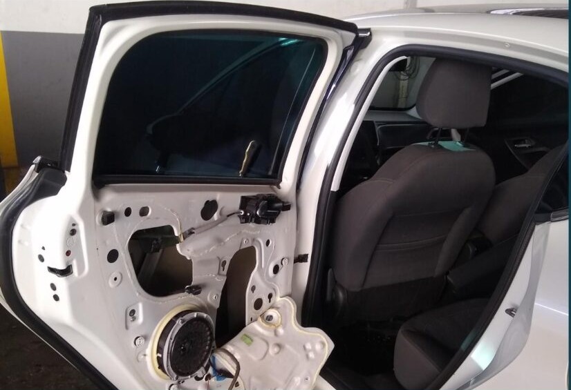 Porta de carro aberta mostrando o mecanismo de vidro e fechadura